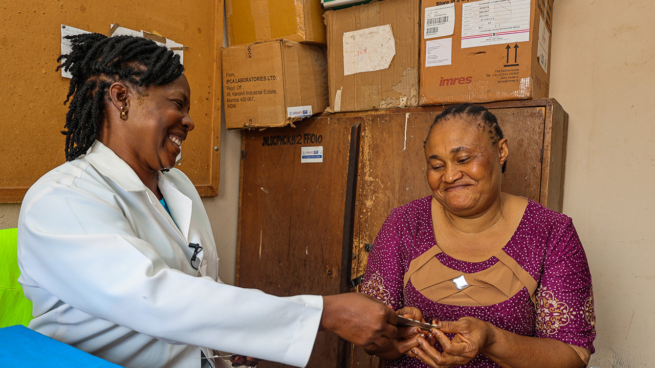 A nurse administers antimalarial treatment to a woman in Nigeria