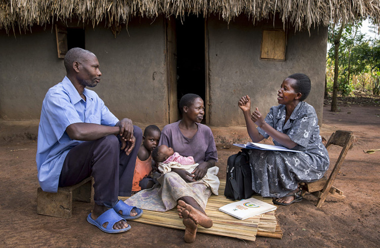 A female community health worker provides family planning options to a family in Uganda