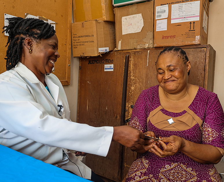 A nurse administers antimalarial treatment to a woman in Nigeria