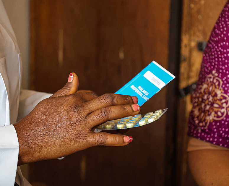 A nurse administers antimalarial treatment to a woman in Nigeria