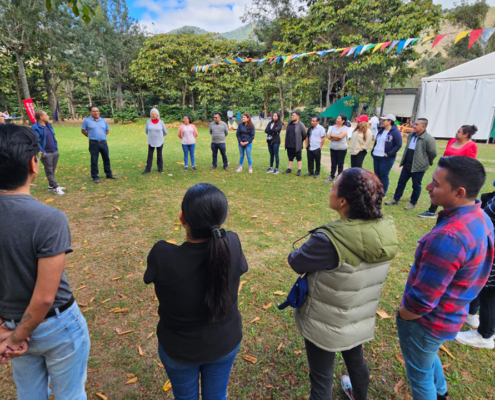 A larger group stands in a circle outside in Guatemala