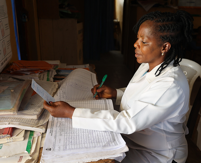 A nurse records data from a malaria referral card in Nigeria