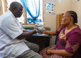 A male health care worker tests a woman for malaria in Nigeria