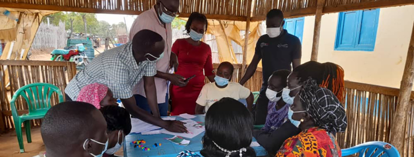 People gather around a table during the design and test phase in South Sudan