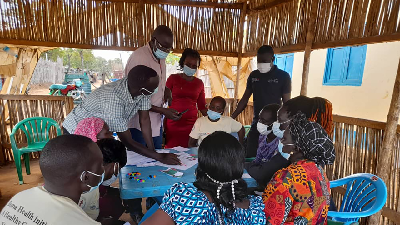 People gather around a table during the design and test phase in South Sudan