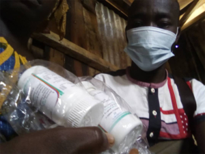 A peer navigator delivers antiretroviral medication to a patient living with HIV in Cote d'Ivoire.