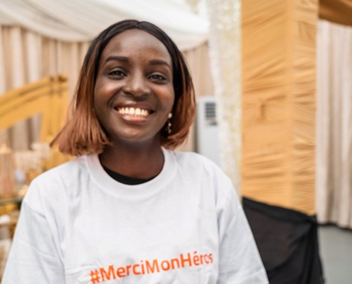 Young woman wearing a Merci Mon Héros t-shirt in the DRC