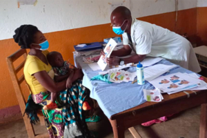 Healthcare worker showing a Breakthrough ACTION tool on complementary feeding of a child who is sick to a mother.