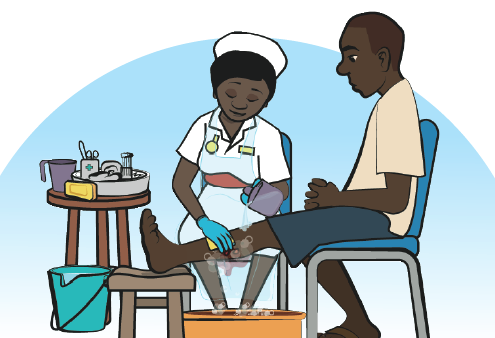 A health worker wearing protective gloves washes a bite on a person's leg with soap and water. The wounded person sits with their leg elevated. First aid and cleaning materials sit on a table nearby.